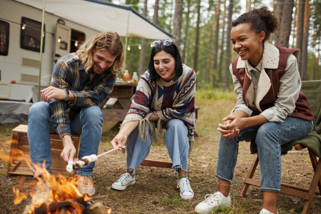 Group,Of,Young,People,Roasting,Marshmallows,While,Enjoying,Camping,With friends toasting marshmallows